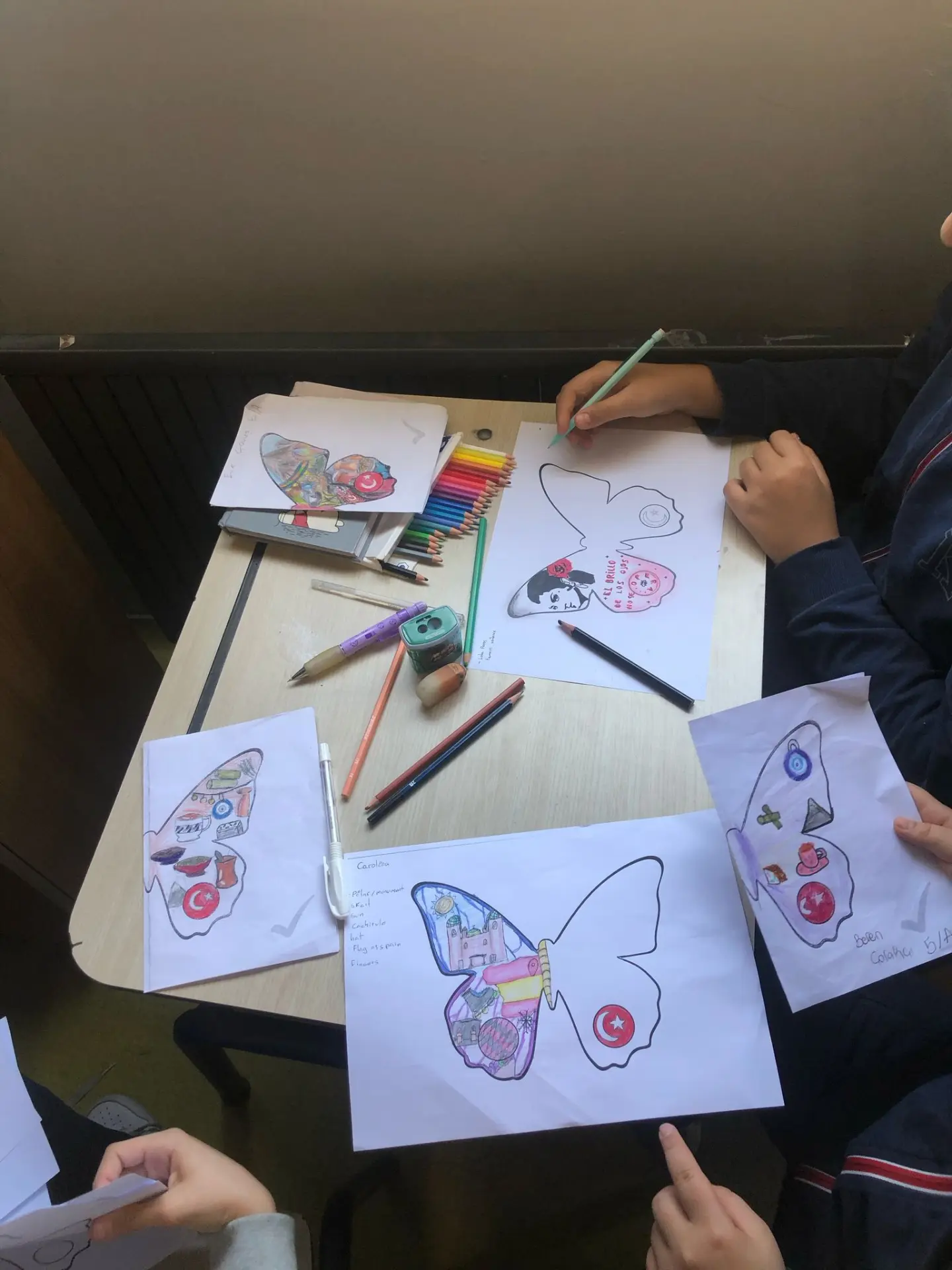 Students drawing their butterflies in class